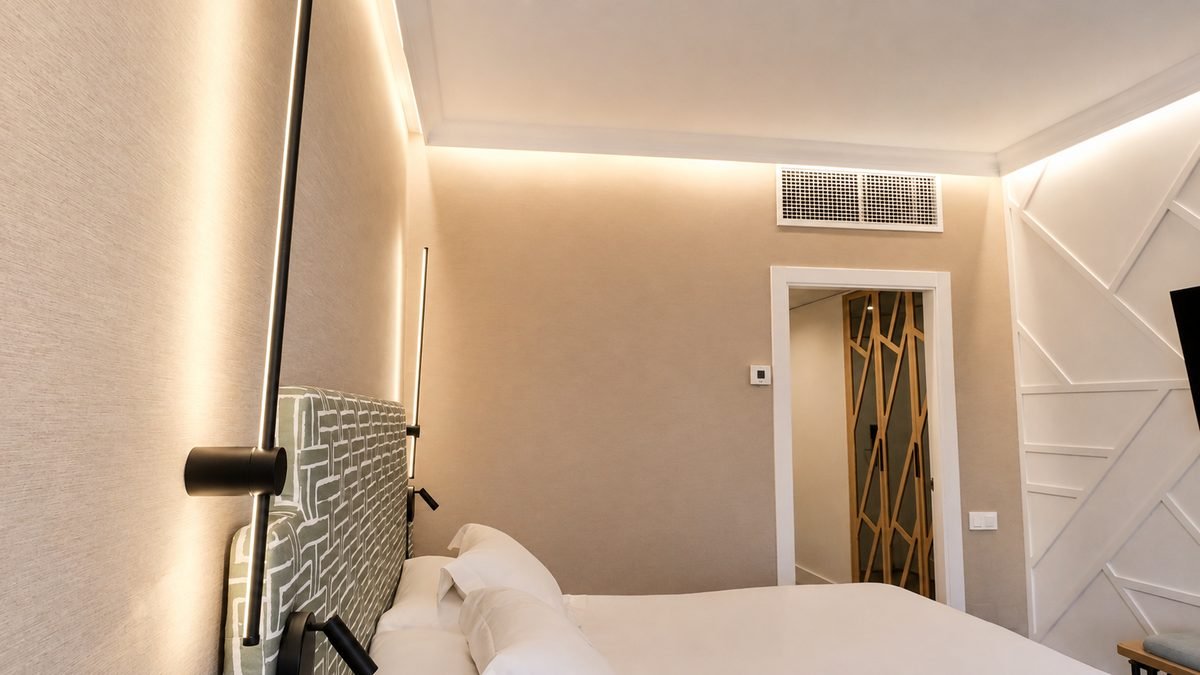 Panelado y celosía de madera en habitación de hotel Vincci — IE Contract